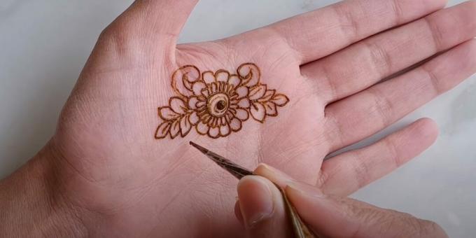 Henna -ritningar på handen: rita lockar och grenar