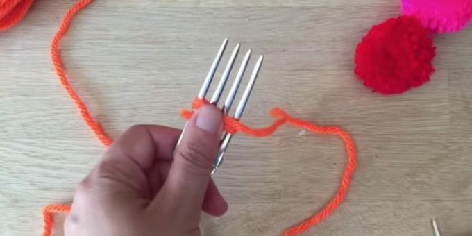 Hur man gör en pompon: börja linda gaffeln med tråd