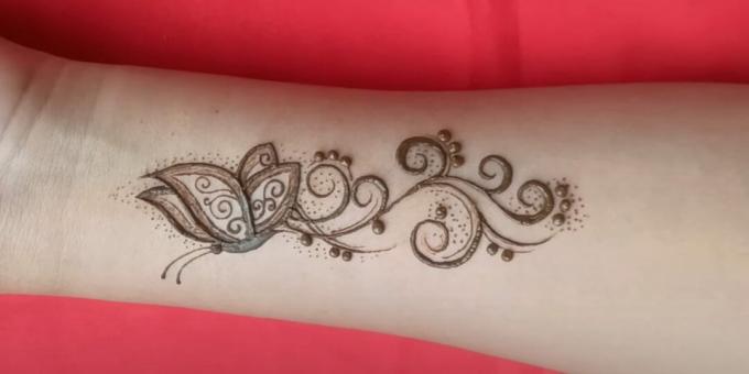 Henna fjärilsteckning på handen: dekorera tatueringen med prickar
