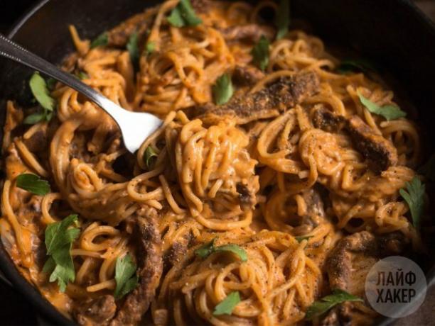 Pasta med nötkött i tomat-gräddsås, serverad strö med persilja och peppar