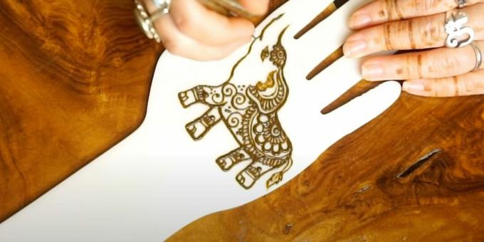 Hennateckning av en elefant på handen: lägg till ett mönster i örat och magen