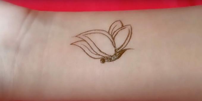 Henna fjärilsteckning på handen: skildrar vingarna