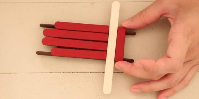 Leksaker på granen med händerna: Paint pinnar och bildar en släde