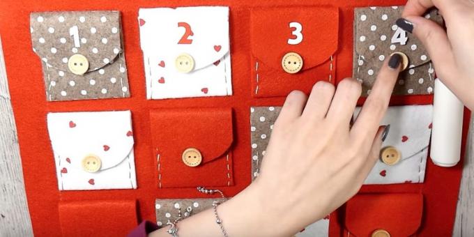 Adventskalender med dina egna händer: Limma flikarna på fickorna och knappar och siffror